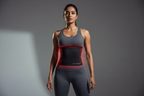 “High-impact, photorealistic hero image for a premium fitness brand. An Indian woman stands confidently in a modern, minimal studio, wearing a wide black rubber sweat band that fully covers the entire belly from under the bust to the lower abdomen. The band wraps smoothly around the stomach and sides, showing a subtle sweat and heat effect. Powerful posture, calm confidence, soft dramatic lighting, clean background. Premium, bold, modern, and empowering brand aesthetic.”